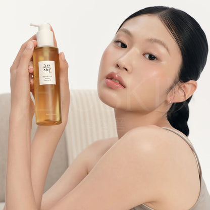 Fille qui tiens l'huile nettoyante au ginseng de Beauty of Joseon dans sa main