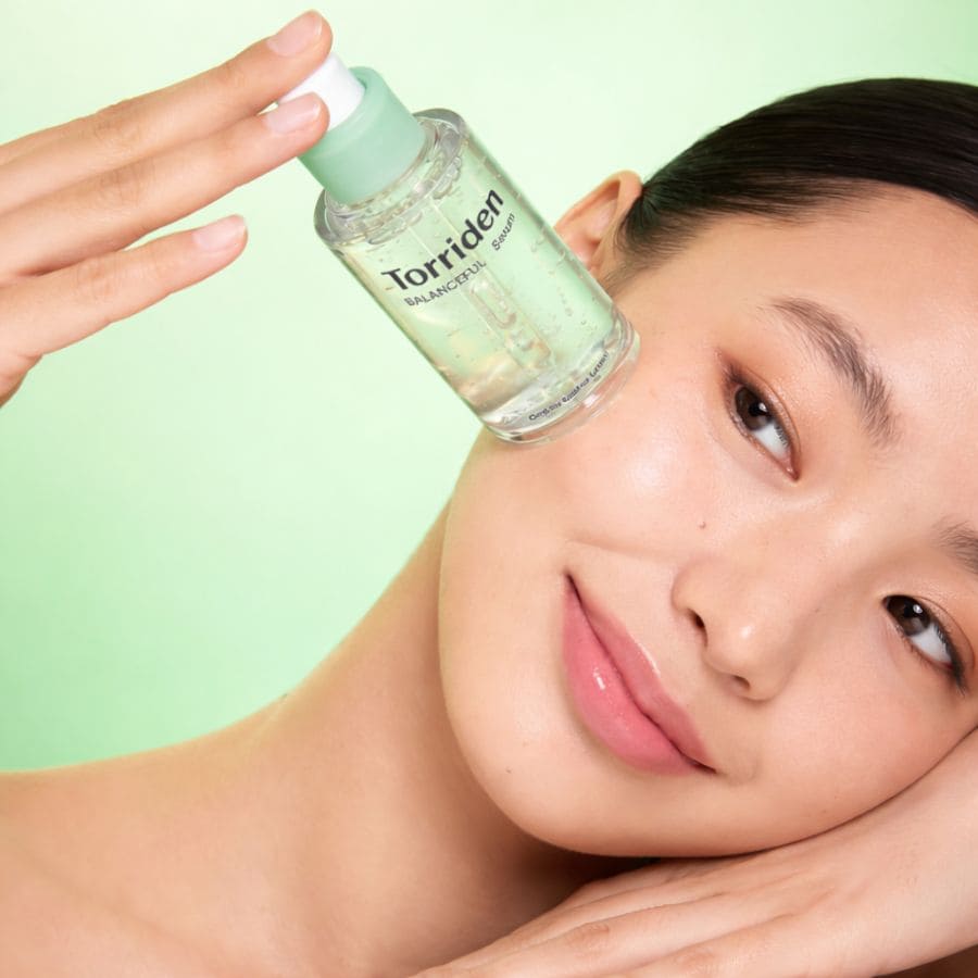 Visage d'une femme avec le serum torriden sur la joue
